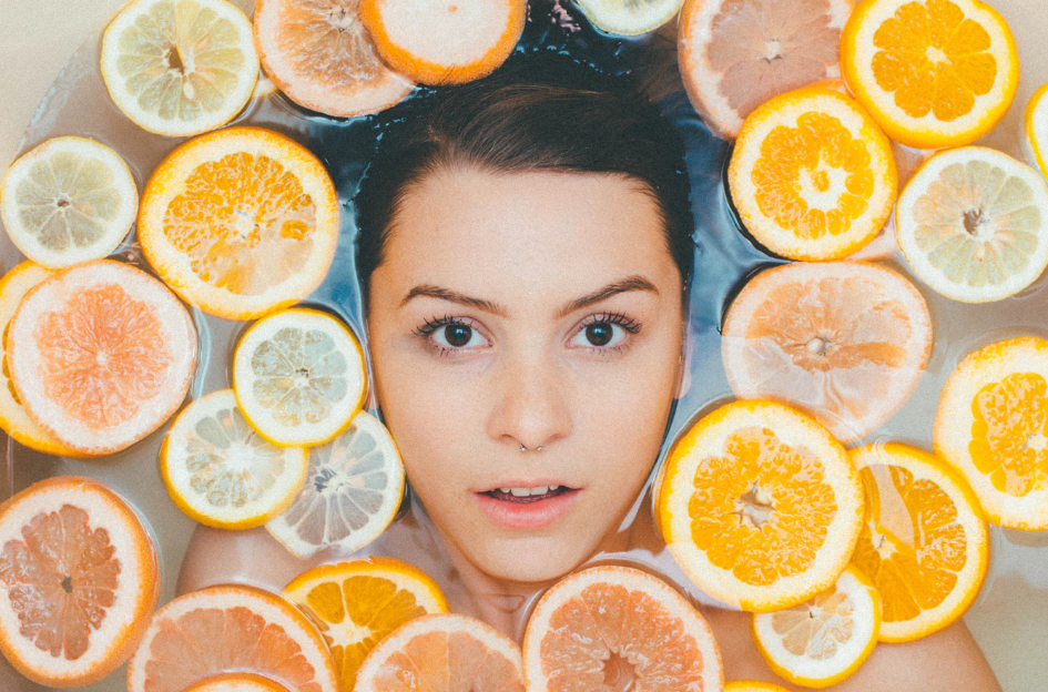woman's face surrounded by lemon an doranges